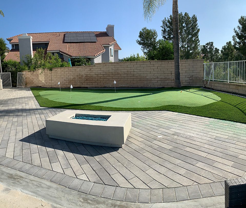 Modern and Large putting range with built-in firepit and custom pavers