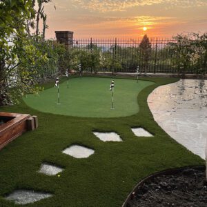 A custom installed putting green at sunset