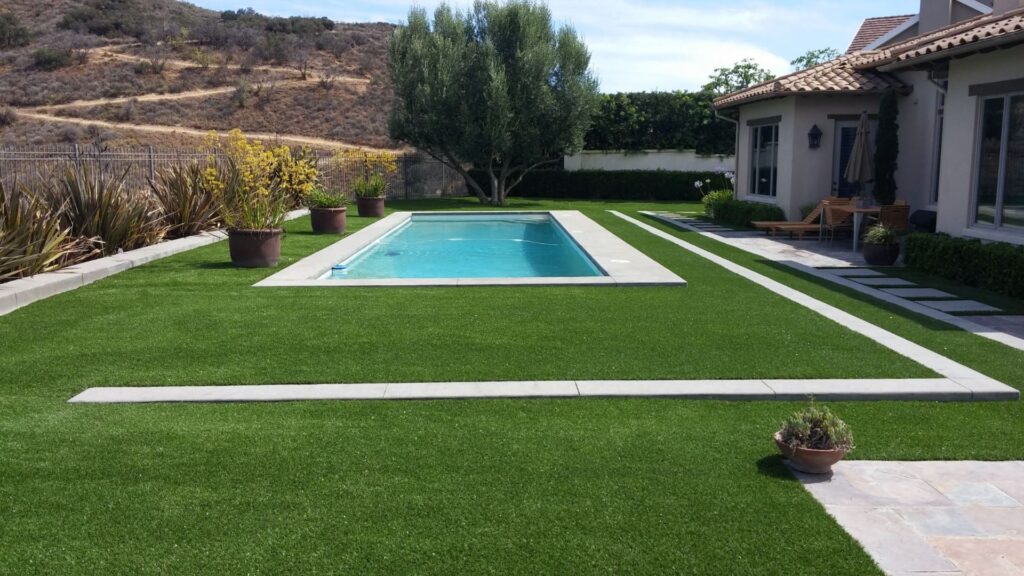 A backyard with artificial grass and a pool perfect for dogs in Orange County.